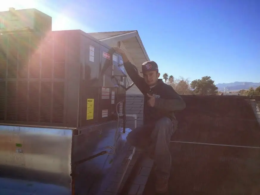 HVAC technician performing Air Duct Repair on a rooftop unit in Breitung